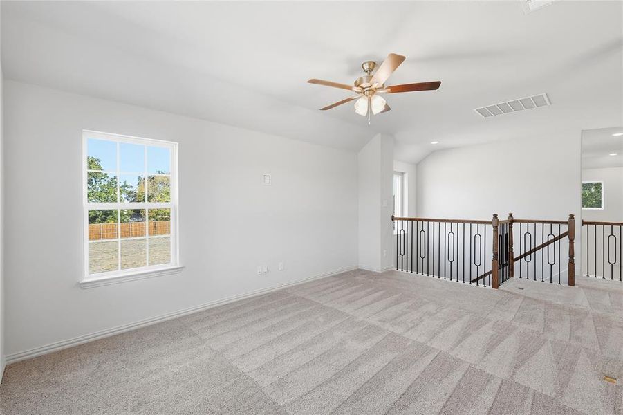Empty room featuring lofted ceiling, carpet floors, ceiling fan, and recessed lighting