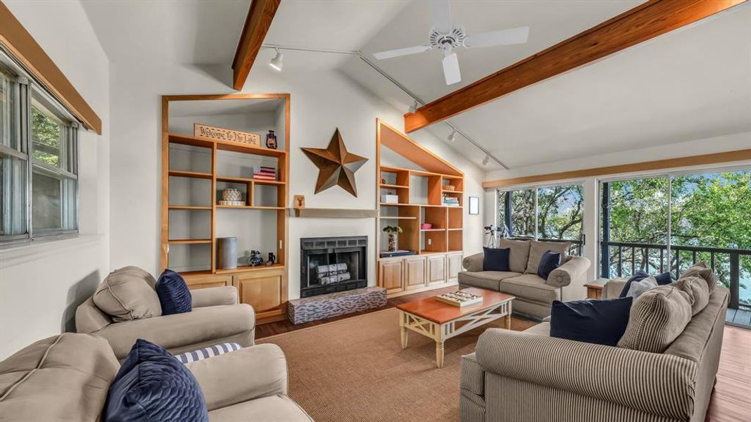 Living area with vaulted ceiling, a wood burning fireplace, and lots of natural light.