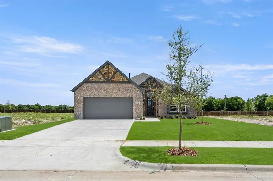 Front exterior of a new home in Oaks of North Grove, Waxahachie, TX, highlighting curb appeal (Image 1). Front exterior of a new home in Oaks of North Grove, Waxahachie, TX, highlighting curb appeal (Image 1).