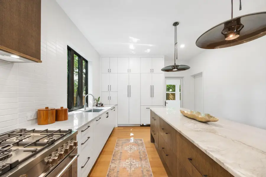 Kitchen with gas range, light wood finished floors, plenty of natural light, brown cabinets, and recessed lighting