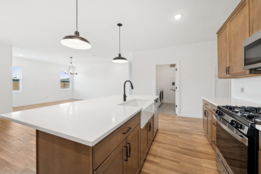 Gorgeous kitchen with chestnut brown cabinets and quartz counters (*Photo not of actual home and used for illustration purposes only.)