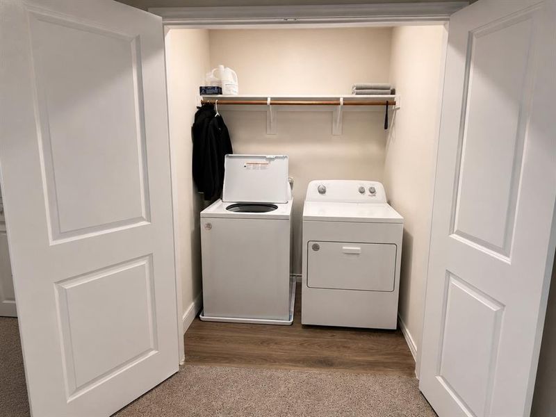 Laundry closet featuring a top-load washing machine, front-load dryer, and a built-in storage shelf Laundry closet featuring a top-load washing machine, front-load dryer, and a built-in storage shelf