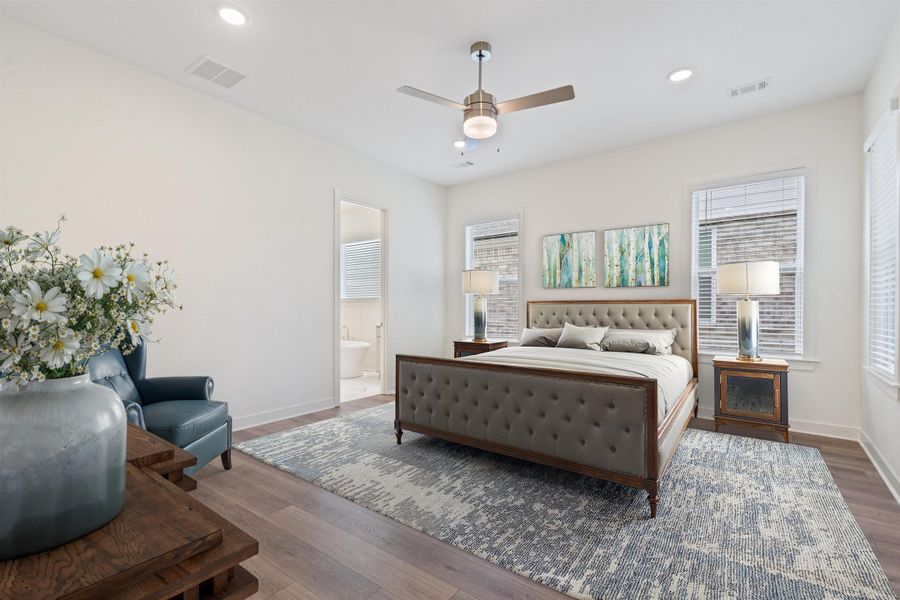 Bedroom with wood finished floors, a ceiling fan, recessed lighting, and connected bathroom