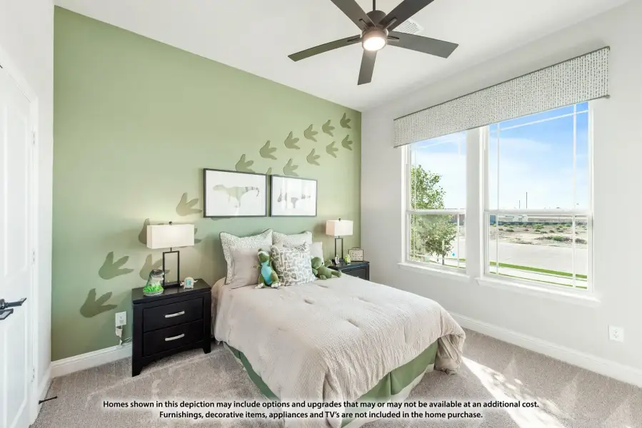 Children's bedroom with green accent wall, dinosaur decor, ceiling fan, and large window