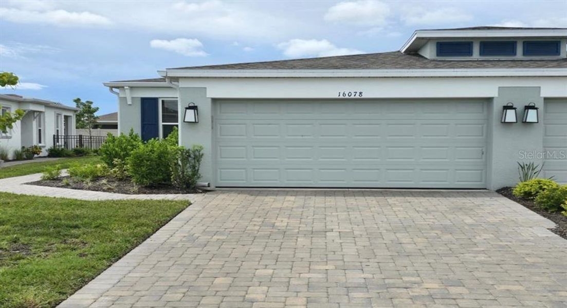 Front exterior of a new home in The Cove at West Port, Port Charlotte, FL, highlighting curb appeal (Image 1). Front exterior of a new home in The Cove at West Port, Port Charlotte, FL, highlighting curb appeal (Image 1).