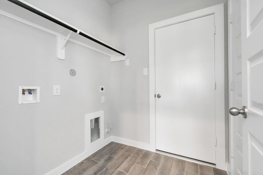 Utility room in house. Both electric and gas dryer connections. Sample photo of completed home with similar floor plan. Actual colors and selections may vary.