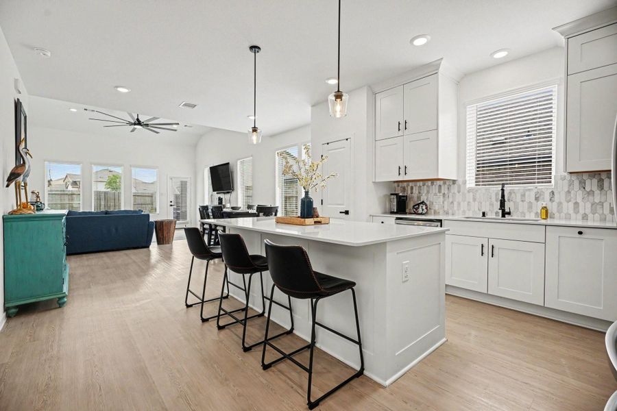 Open-concept kitchen and living area highlighted by a large island with seating, abundant cabinetry, and plenty of natural light. Open-concept kitchen and living area highlighted by a large island with seating, abundant cabinetry, and plenty of natural light.