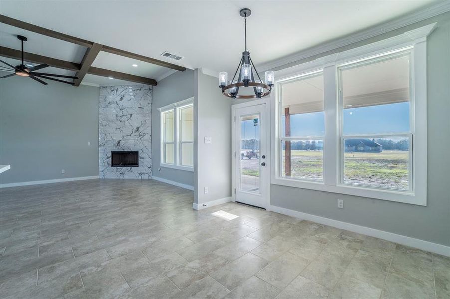 Unfurnished living room featuring coffered ceiling, a high end fireplace, beamed ceiling, a chandelier, and recessed lighting Unfurnished living room featuring coffered ceiling, a high end fireplace, beamed ceiling, a chandelier, and recessed lighting