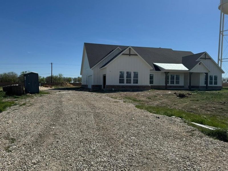 View of front of house featuring gravel driveway and board and batten siding