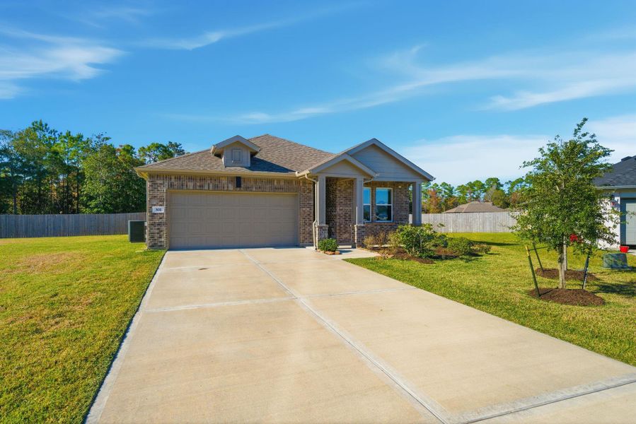 Charming single-story home with a two-car garage, brick exterior, and neat landscaping. It features a spacious driveway and a large, fenced backyard, offering privacy and ample outdoor space. Perfect for comfortable family living.