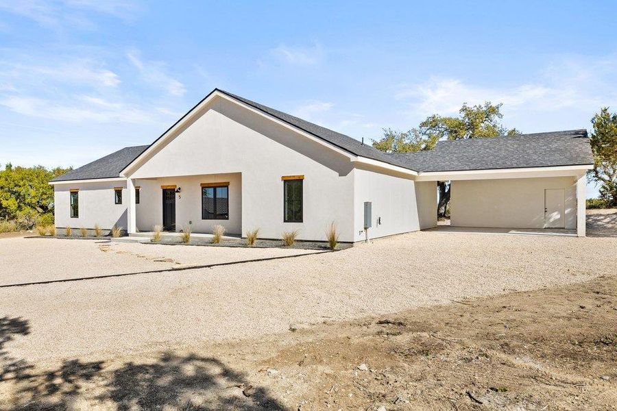 View of front of property with a porch, stucco siding, and driveway