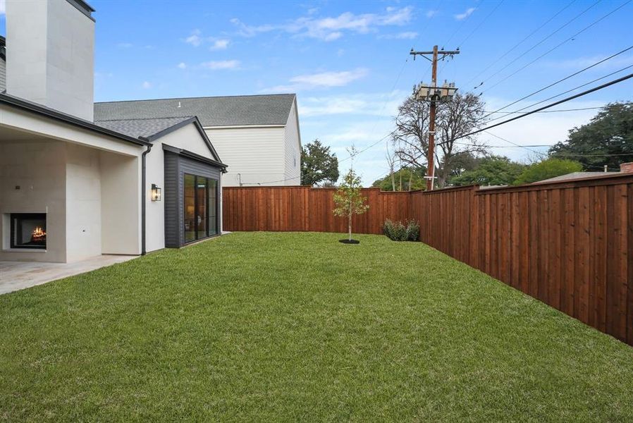 Fenced backyard with a warm lit fireplace Fenced backyard with a warm lit fireplace