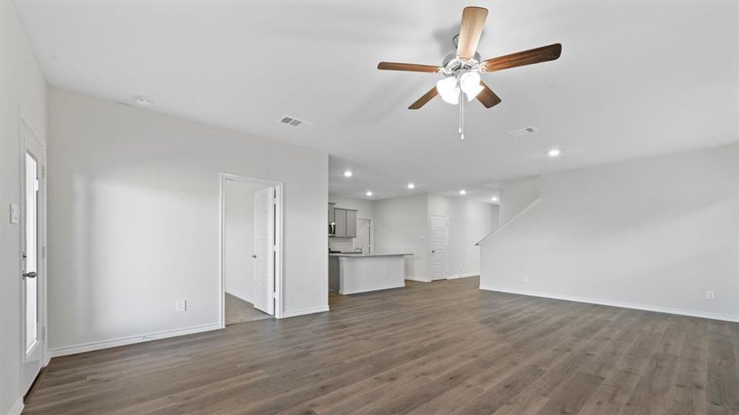 Unfurnished living room featuring ceiling fan, dark wood-style flooring, and recessed lighting Unfurnished living room featuring ceiling fan, dark wood-style flooring, and recessed lighting