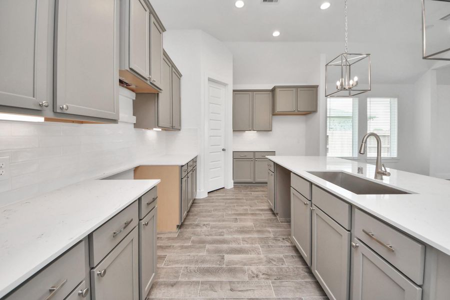 The kitchen is a culinary haven, featuring granite countertops, a tile backsplash, stainless steel appliances, 42” upper cabinets, and undercabinet lighting.