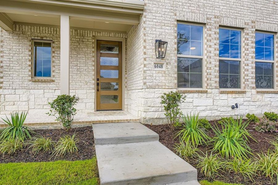 Doorway to property featuring covered porch and stone siding Doorway to property featuring covered porch and stone siding