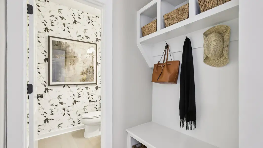 Built-in white painted drop zone near garage access and powder room