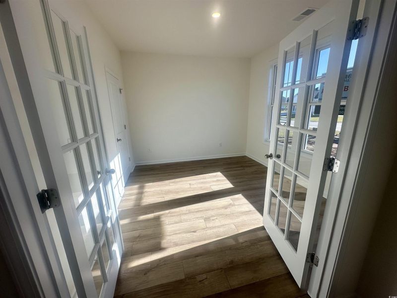 Home Office with French doors and dark wood-type flooring