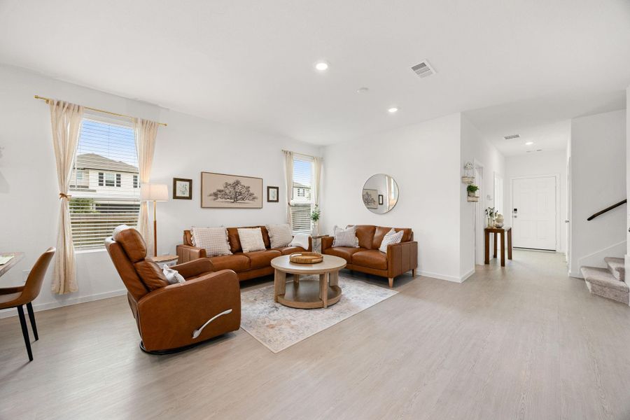 Natural light fills the open-concept living room, offering the perfect space for gathering with family and friends while maintaining sightlines to the kitchen and dining area.