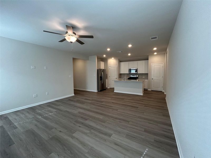 Unfurnished living room featuring a ceiling fan, recessed lighting, and dark wood-style floors Unfurnished living room featuring a ceiling fan, recessed lighting, and dark wood-style floors
