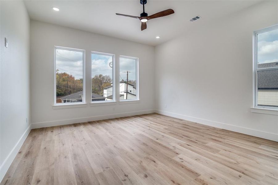 Empty room featuring light wood-style floors, ceiling fan, and recessed lighting