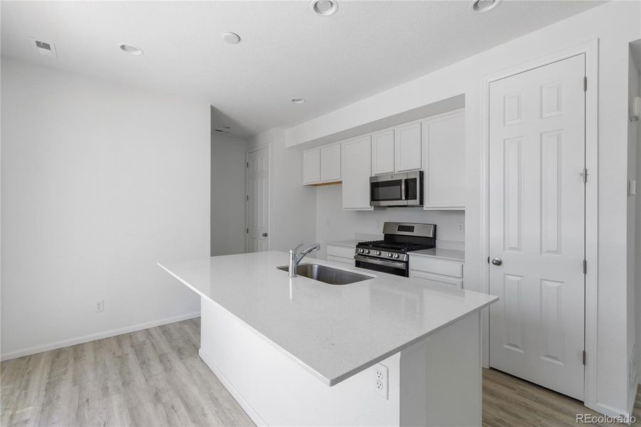 Kitchen features island with breakfast bar, LVP flooring