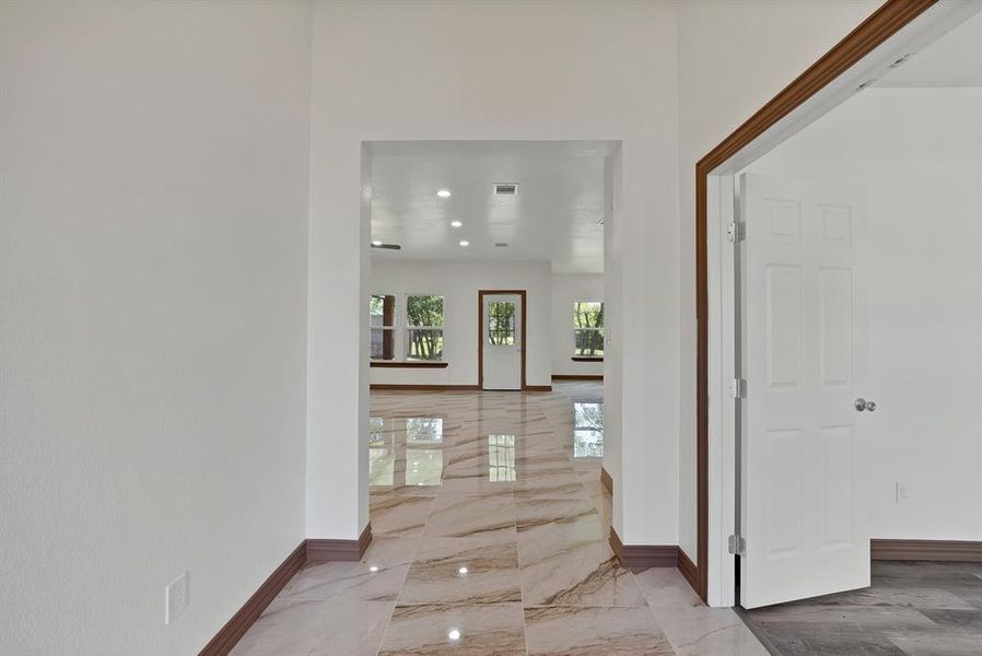 Foyer entrance with light marble finish floors and recessed lighting