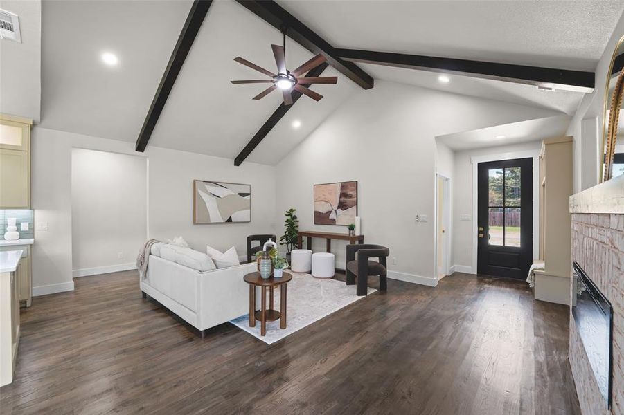 Living area featuring a vaulted ceiling with exposed dark wood beams, wood-finish flooring, recessed lighting, and a dark wood ceiling fan Living area featuring a vaulted ceiling with exposed dark wood beams, wood-finish flooring, recessed lighting, and a dark wood ceiling fan