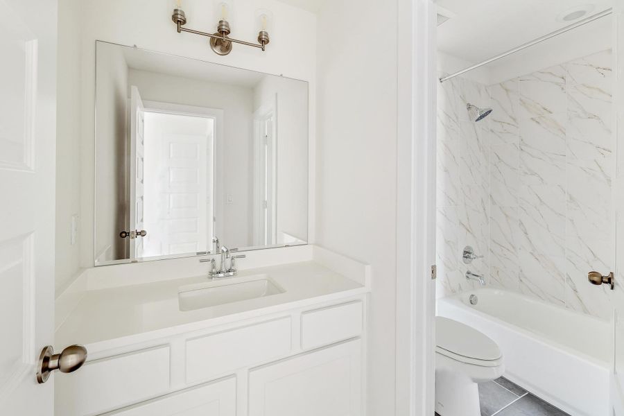 Bathroom with tile patterned floors, toilet, bathtub / shower combination, and vanity Bathroom with tile patterned floors, toilet, bathtub / shower combination, and vanity