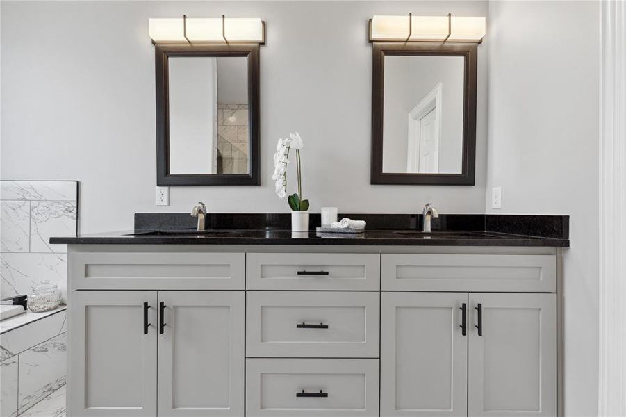 Bathroom featuring marble finish floor, a sink, and double vanity