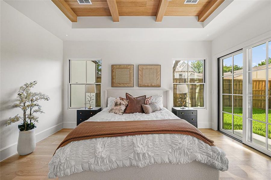 Recessed tray ceiling featuring exposed wood beams and recessed lighting