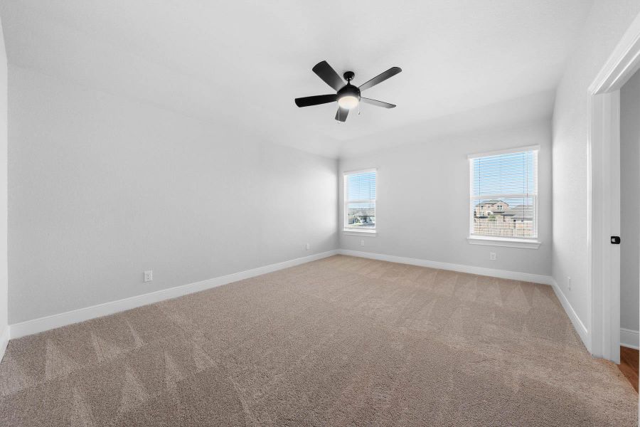 Empty room featuring light colored carpet and ceiling fan
