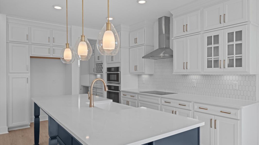 Accomplished kitchen design featuring pendant lighting above a statement island for both prep and gathering