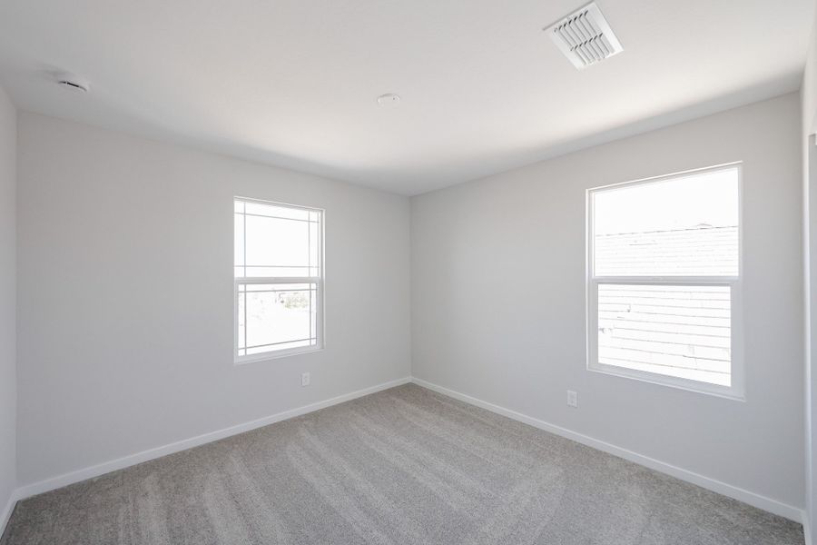 A room with a carpet and windows.