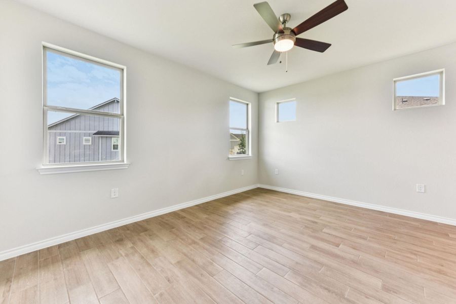 Unfurnished room featuring plenty of natural light, light wood-style flooring, and a ceiling fan