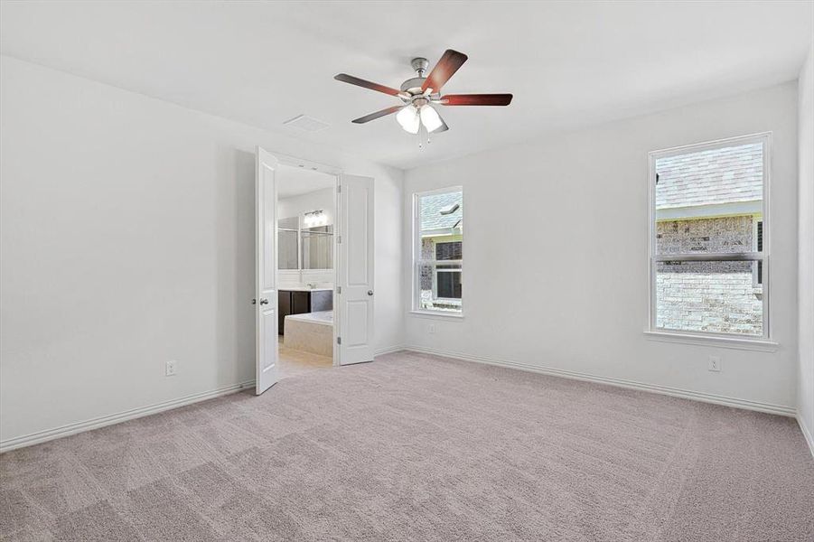 Carpeted spare room featuring ceiling fan