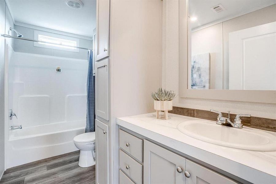 Full bathroom featuring hardwood / wood-style floors, vanity, toilet, and shower / bathtub combination with curtain