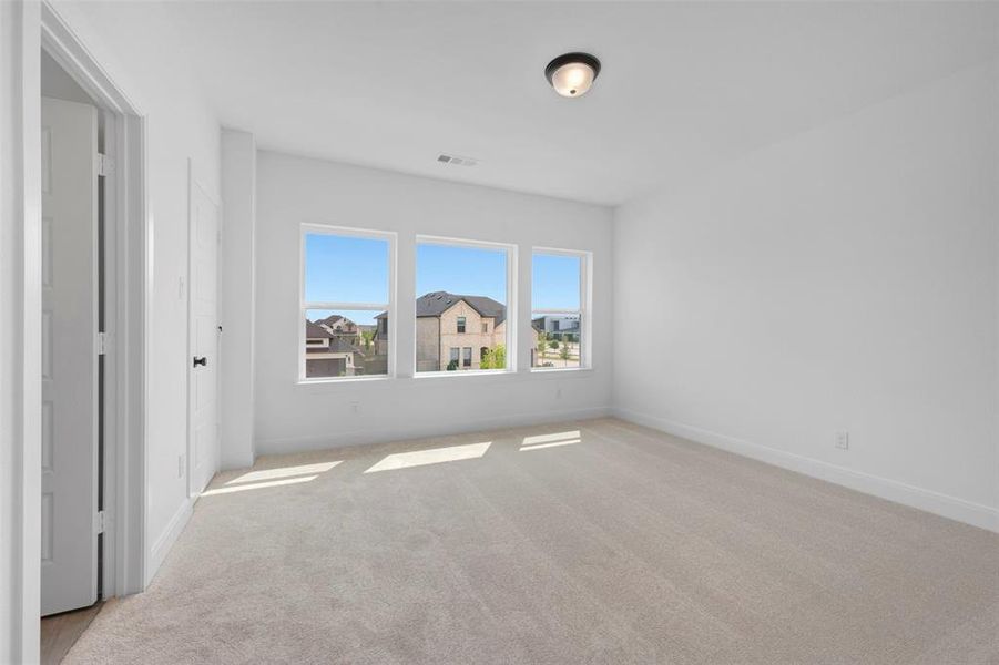 Unfurnished bedroom featuring light colored carpet and baseboards