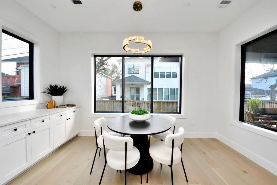 The breakfast area is surrounded by windows, creating a bright and inviting space filled with natural light.