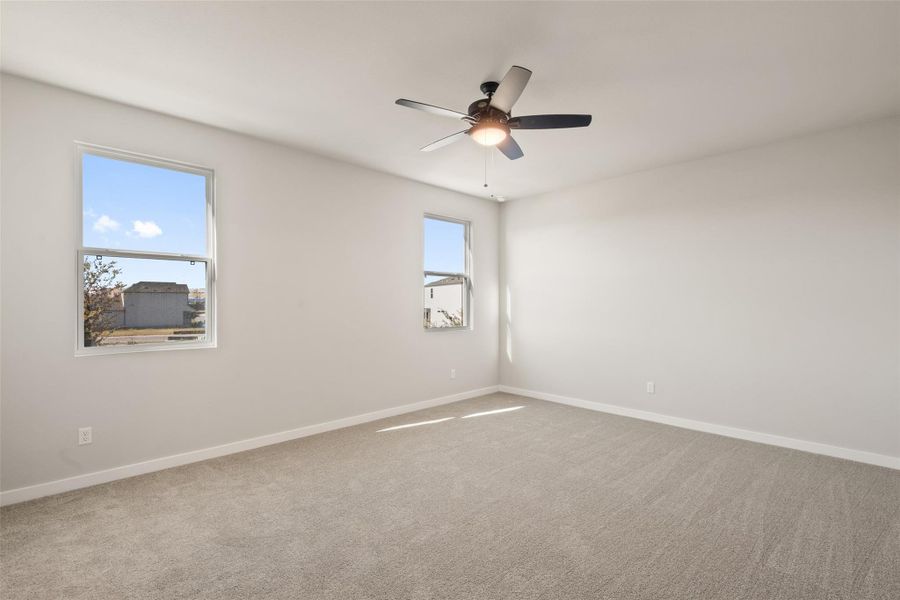 Unfurnished room with light colored carpet and ceiling fan