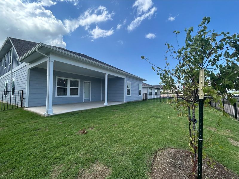 Rear view of house with a patio area and a shingled roof Rear view of house with a patio area and a shingled roof