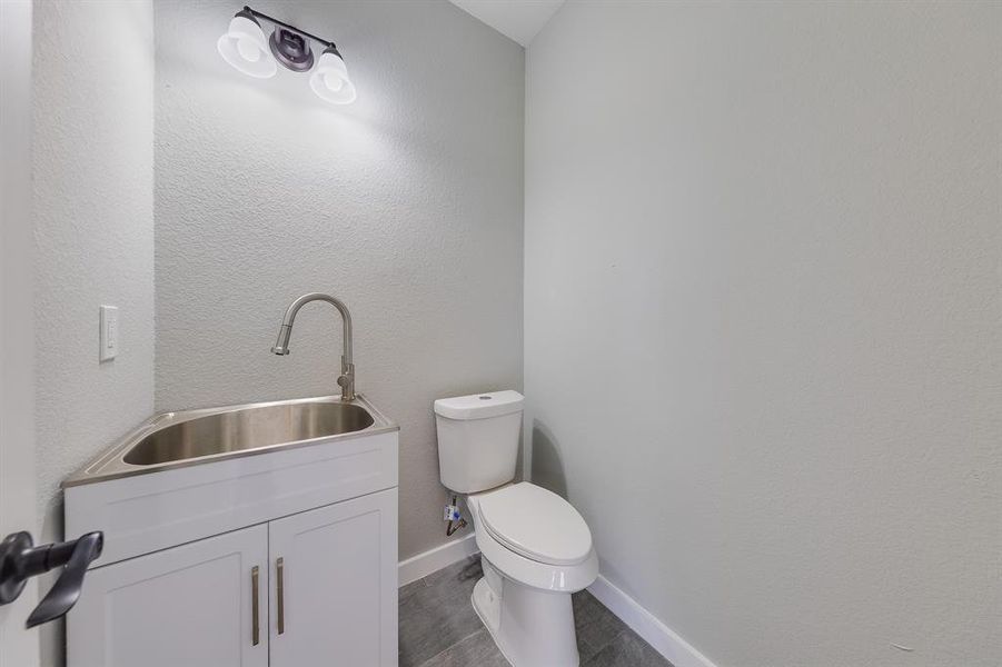 Mudroom or half bath conveniently located at the back patio, offering easy access and functionality for outdoor activities.