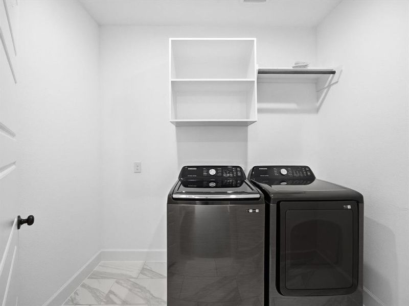 Washroom featuring light marble finish floors and separate washer and dryer Washroom featuring light marble finish floors and separate washer and dryer