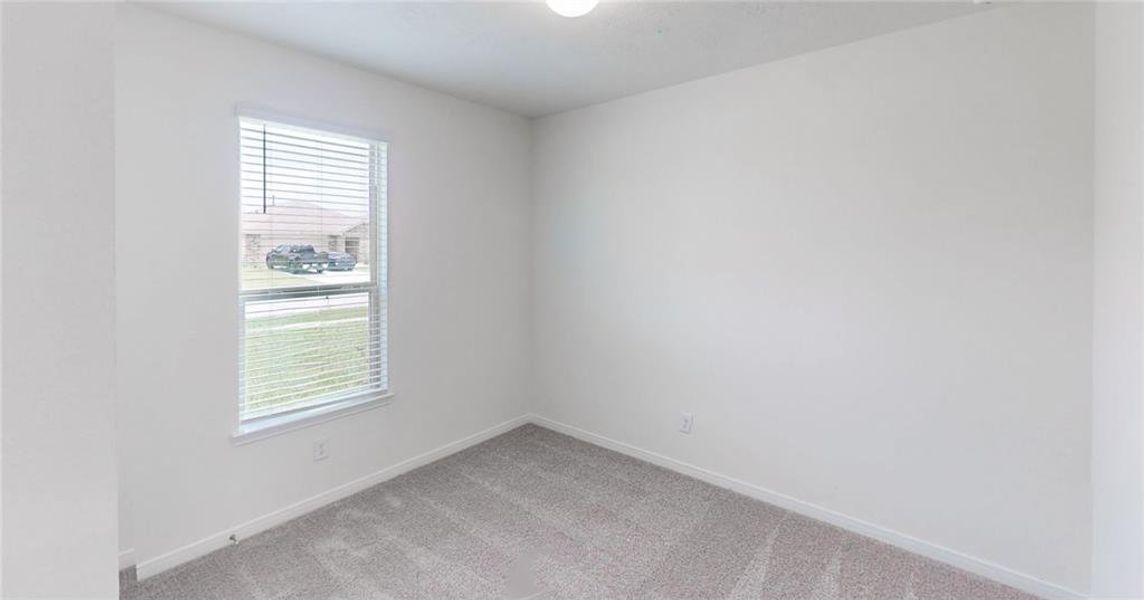 Secondary bedroom features plush carpet, custom paint and a large window.