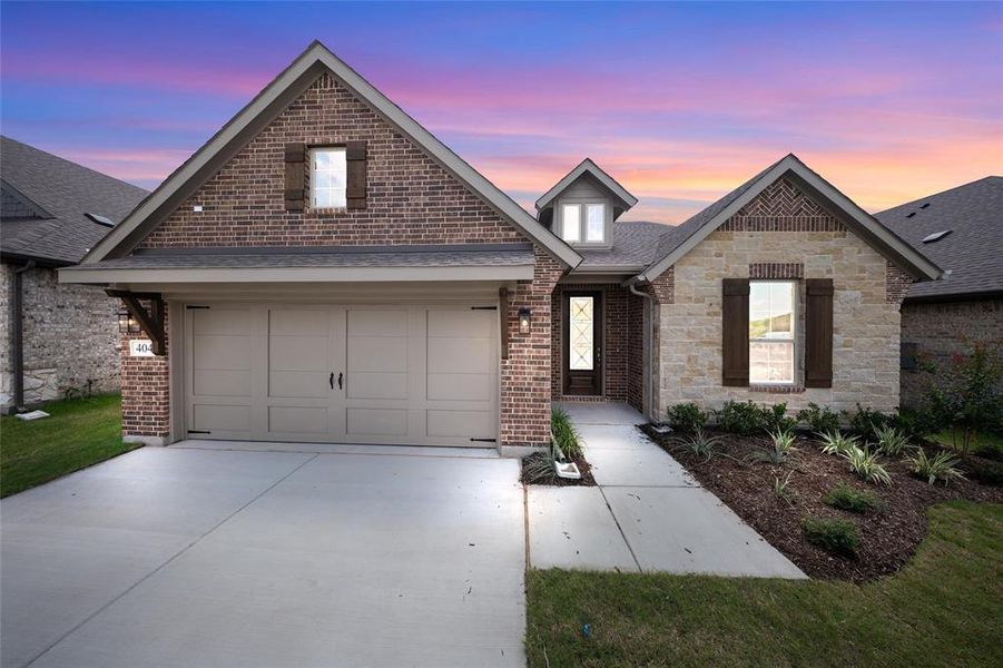 View of front of home with driveway, a garage, brick siding, and roof with shingles