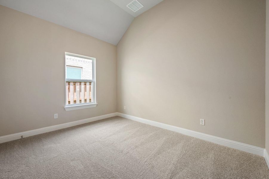 Carpeted spare room with lofted ceiling and baseboards