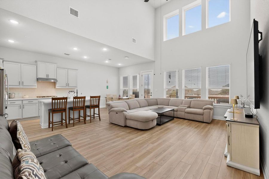 Living area featuring light wood finished floors, ceiling fan, and recessed lighting