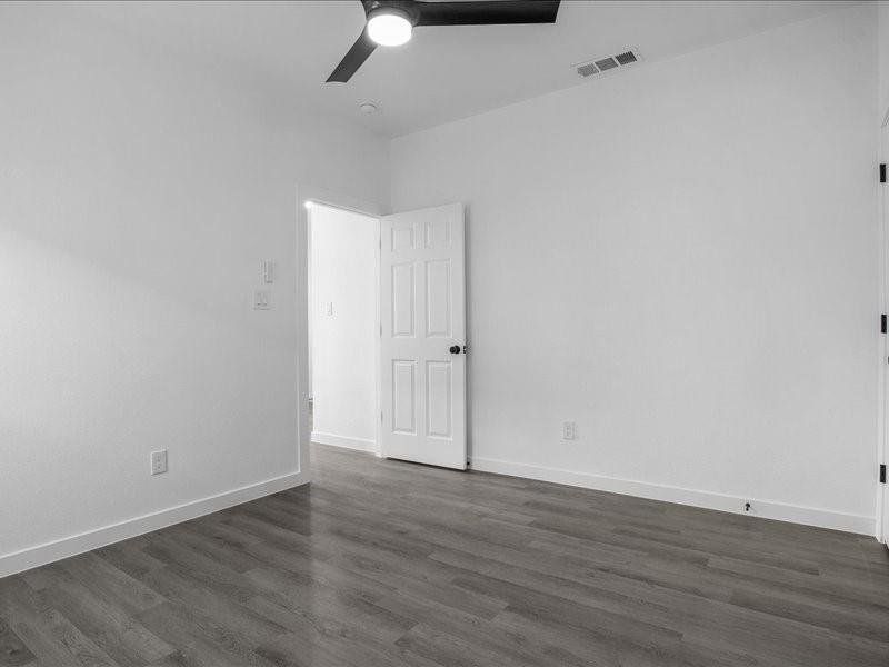 Unfurnished room featuring dark hardwood / wood-style flooring and ceiling fan