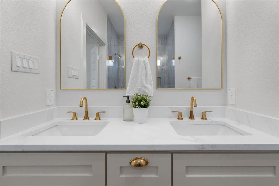 Bathroom with a textured wall and double vanity