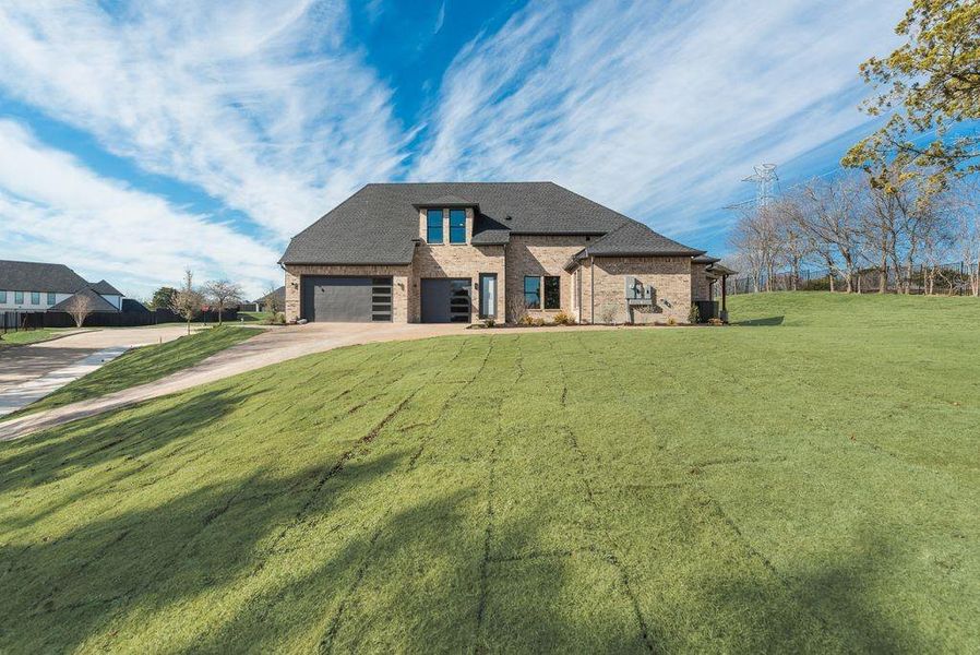 View of front of property with a front lawn and a garage