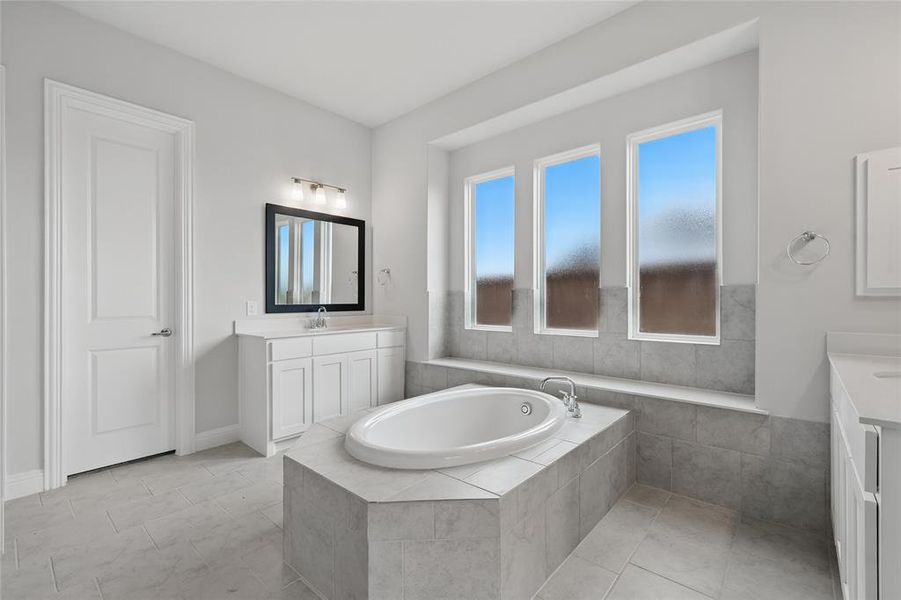 Bathroom with two vanities, a garden tub, and tile patterned flooring